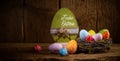 German greetings Frohe Ostern  english translation happy easter  Colorful painted eggs in birds nest basket on rustic wooden old Royalty Free Stock Photo