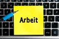 The german inscription `Arbeit` on a yellow sheet of sticker paper