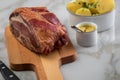 German Kassler pork neck with boiled potatoes and mustard on marble table