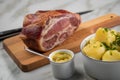 German Kassler pork neck with boiled potatoes and mustard on marble table