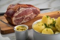 German Kassler pork neck with boiled potatoes and mustard on marble table