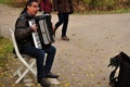 German man people playing accordion organ musical keyboard instruments for show travelers at Leopold garden public park fall