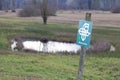 German nature conservation area shield in front of a moor landscape with a small lake in the background, german text translation: