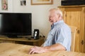 German old man sitting on chair in dining room waiting lunch