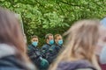 German police officer wearing blue medical face masks, framed by intentionally blurred heads of blond demonstrators