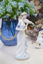 German porcelain figurine of a violinist girl. Ceramic figurine of the violoncellist in retro style with blue flowers on the table