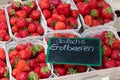 German red strawberries market baskets with black label sign Royalty Free Stock Photo