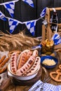 German sausages on the grill. Traditional German sausages and pastry brezel for a beer festival. Wood background and