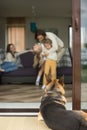 German shepherd looking inside house with family, rear vertical Royalty Free Stock Photo