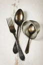 German silver spoon, fork and other utensils on a white wooden b Royalty Free Stock Photo
