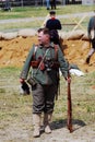 German soldier-reenactor stand holding a gun.