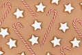 German star shaped glazed Christmas cookies called `Zimtsterne` and candy canes on brown background Royalty Free Stock Photo