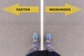 German text Fakten and Meinungen on asphalt ground, feet and shoes on floor Royalty Free Stock Photo