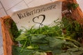 German text on the hand-painted sign reads: Small animal feed. a wicker basket with herbs, leaves etc.