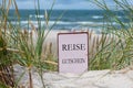 The German text \'Reise Gutschein\' (travel voucher) in the sand dunes at the beach Royalty Free Stock Photo