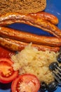 German traditional simple meal: grilled sausages, sauerkraut and bread, details, closeup Royalty Free Stock Photo