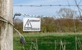 An electrified fence with German warning in the countryside