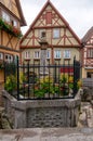 German wood framed houses and little fenced fountain at Plonlei