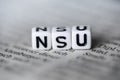 German Word NSU formed by wood alphabet blocks on newspaper