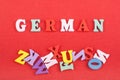 German word on red background composed from colorful abc alphabet block wooden letters, copy space for ad text. Learning english Royalty Free Stock Photo