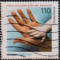 GERMANY - CIRCA 1999 : a postage stamp from Germany, showing a hand of a child in the hand of a senior. International Year of Seni