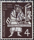GERMANY - CIRCA 1954: On this postage stamp printed in Germany, Johannes Gutenberg can be seen printing the first Bible on a print