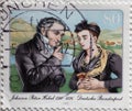 GERMANY - CIRCA 1985 : a postage stamp from Germany, showing a portrait of the clergyman and writer Johann Peter Hebel with a woma