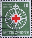 GERMANY - CIRCA 1953:On this postal stamp printed in Germany, you can see the symbol of the Red Cross in a stylized wind rose. The