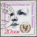 GERMANY, DDR - CIRCA 1971: a postage stamp from Germany, GDR showing a child`s face, emblem of UNICEF, 25 years of the United Nat