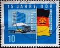 GERMANY, DDR - CIRCA 1964 : a postage stamp from Germany, GDR showing the flag of the GDR in front of the teacher`s house and blo Royalty Free Stock Photo