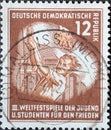 GERMANY, DDR - CIRCA 1951 : a postage stamp from Germany, GDR showing Flag-raising youth in front of the Brandenburg Gate. III. Wo