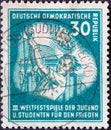 GERMANY, DDR - CIRCA 1951 : a postage stamp from Germany, GDR showing Flag-raising youth in front of the Brandenburg Gate. III. Wo