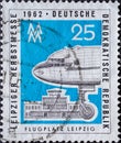 GERMANY, DDR - CIRCA 1962 : a postage stamp from Germany, GDR showing the front part with nose wheel of an airplane, in front of t