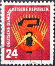 GERMANY, DDR - CIRCA 1951 : a postage stamp from Germany, GDR showing the number `5` in front of the hammer, compass and ear of