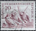 GERMANY, DDR - CIRCA 1961 : a postage stamp from Germany, GDR showing portrait of three fishermen in work clothes with hats haulin