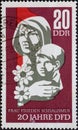 GERMANY, DDR - CIRCA 1967 : a postage stamp from Germany, GDR showing a woman with a child and a flower. 20 years of the Democrati