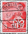 GERMANY, DDR - CIRCA 1956  : a postage stamp from Germany, GDR showing a worker with a flat cap and VEB emblem, factory. 10 years Royalty Free Stock Photo