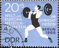 GERMANY, DDR - CIRCA 1966 : a postage stamp from Germany, GDR showing bumping into an athlete while lifting weights. World and Eu