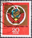 GERMANY, DDR - CIRCA 1972: a postage stamp from Germany, GDR showing the emblem of the USSR with hammer and sickle on red postal s