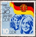 GERMANY, DDR - CIRCA 1979 : a postage stamp from Germany, GDR showing Faces of young people in front of the flag of the GDR: 30 ye