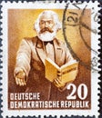 GERMANY, DDR - CIRCA 1953 : a postage stamp from Germany, GDR showing Karl Marx reads from his work `Das Kapital`. On the 70th a Royalty Free Stock Photo