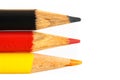 Germany flag colours in coloured pencils in black, red and gold in closeup photo isolated on white background with copy space Royalty Free Stock Photo