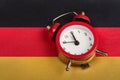 Germany flag and vintage alarm clock close up. Time to learn German Royalty Free Stock Photo