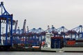 Container port, freighter vessels are mooring on the quay, in background a tangle of
