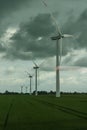 Perspective view of wind turbine in rural Germany view from window of moving train in summer with cloudy dark sky Royalty Free Stock Photo