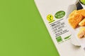 Package of vegan meat substitute food with label and German text on green background with copy space