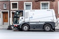 A special truck or street cleaning vehicle rides along the road and cleans the street from dirt and dust.