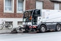 A special truck or street cleaning vehicle rides along the road and cleans the street from dirt and dust.