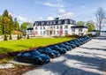Germany, Munich, 26 April 2019: Aerial video of the group of black sports cars are before the white building of hotel in a sunny