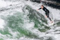 Germany, Munich - September 01, 2013. Atractive sporty man in neoprene shorty surfing on famous artificial river wave